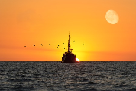 船サンセットは鳥で飛んでいくと夕焼けの空に昇る月の群れと古い 船サンセットは鳥で飛んでいくと夕焼けの空に昇る月の群れと古い