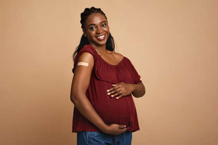 Cheerful pregnant black woman got vaccinated against covid-19 Фото со стока