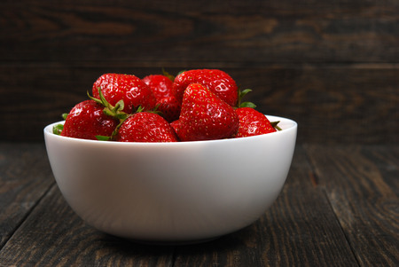 Lein-Wand-Bild Essensbilder Früchte Erdbeeren in weißer Schale auf dunklem Holz
