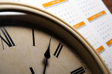 sheet of a calendar with the number of days and clock close up stock