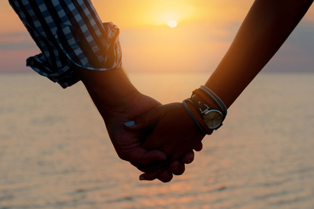 愛するカップル 男と女の子のシルエット は 桟橋で海に夕日の光線で手を握る の写真素材 画像素材 Image