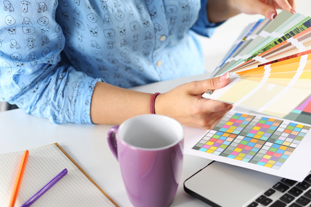 hands of female designer in office working with colour samples