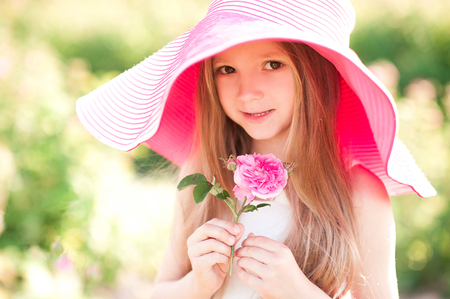 草原で大きな帽子をかぶってかわいい赤ちゃん女の子 4 5 歳開催花の笑顔 カメラを見ています 子供の頃 夏の時間 の写真素材 画像素材 Image