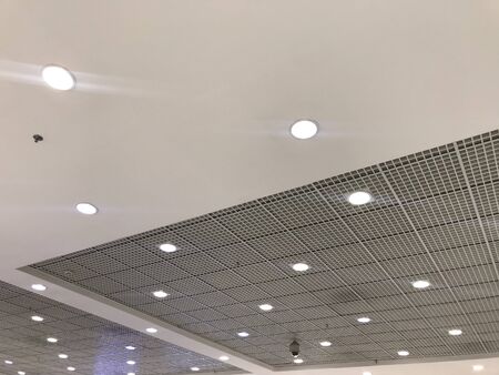 White Color Emulsion Painted Gypsum Ceiling And Macro Grid Ceiling Combined As False Ceiling Interiors For An Commercial Retail Shop Building And Led Lights Fixed For Lighting