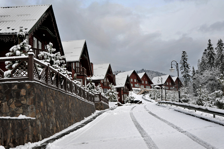 Wooden cottages holiday house in mountain holiday resort covered with fresh snow in winter beautiful winter street after snowfall Imagens