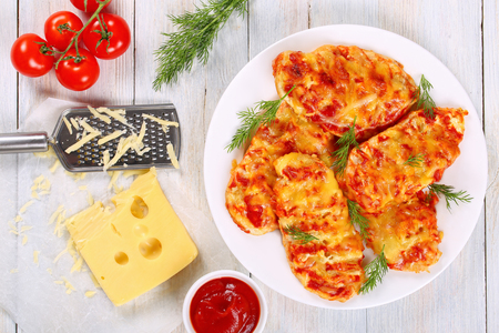 溶けたエメンタール チーズでコーティングされた鶏の胸肉オーブン焼き 野菜の背景 イタリアのレシピの食材を白い皿にトマトソースを上から表示します の写真素材 画像素材 Image