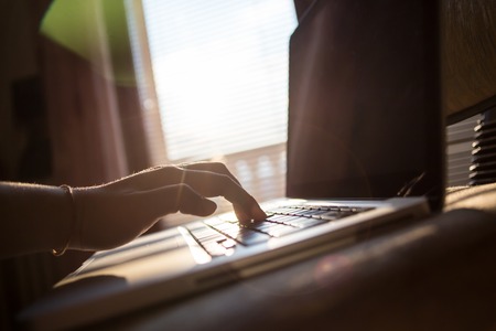 Image of black laptop keyboard with female hands touching it selective focus