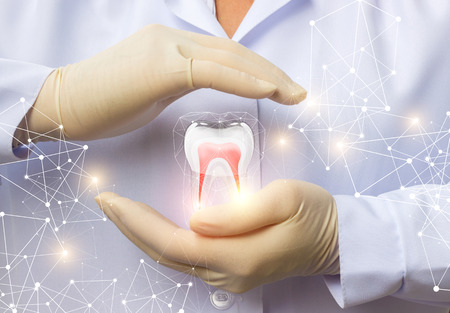 Apoyar la salud dental. El médico, con un gesto de protección del diente. Foto de archivo - 80174157