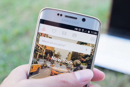 logo samsung: CHIANG MAI THÁI LAN - 21 Tháng 11 năm 2015: Một người đàn ông tay màn hình giữ cú sút Airbnb trên cạnh samsung galaxy s6. một nền tảng trực tuyến cho chỗ ở, tìm kiếm và thuê nhà ở tư nhân ngắn hạn trên toàn thế giới