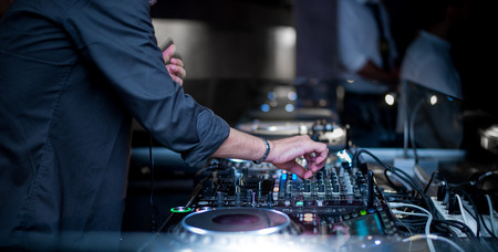 Party people dj playing music on the turntable with the hands on the mixer console. cool people Stock Photo