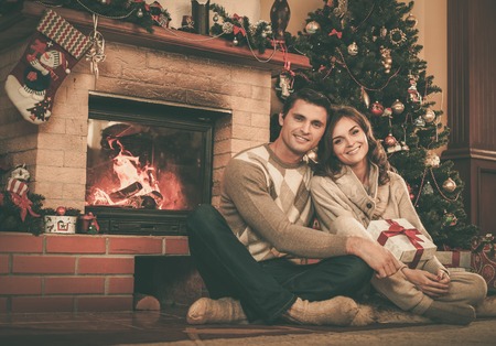 クリスマスの装飾が施された室内には暖炉のそばのカップル の写真素材 画像素材 Image