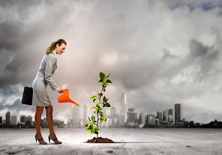 Image of businesswoman watering tree with pot Ecology concept Фото со стока