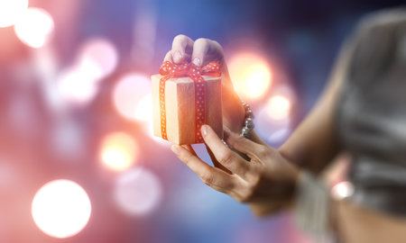 Gros plan des mains donnant une boîte-cadeau surprise