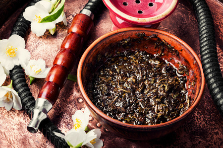 Smoke hookah with jasmine floral scent.Shisha concept.Modern hookah Фото со стока
