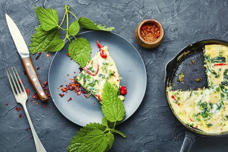 Omelette savoureuse aux herbes fraîches et aux orties dans une poêle