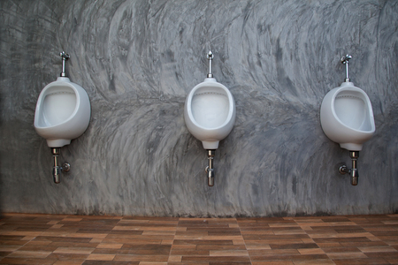 closeup of three white urinals in men s bathroom design of white
