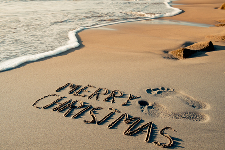 some foot prints and the text merry christmas written in the sand of a beach stock - Merry Christmas Beach Images some foot prints and the text merry christmas written in the sand of a beach stock - Merry Christmas Beach Images