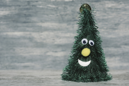 a christmas tree with a funny face against a gray rustic wooden background with a - Rustic Wood Christmas Tree a christmas tree with a funny face against a gray rustic wooden background with a - Rustic Wood Christmas Tree