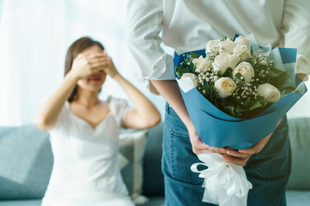 Un jeune couple asiatique heureux à la saint-valentin ou à l'anniversaire reste ensemble, l'homme donne et surprend sa femme un bouquet le jour de la saint-valentin ou de l'anniversaire. mari et femme célébrant le jour de la saint-valentin.