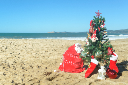 christmas tree and red santa bag of presents at the beach stock photo 91587645 - Christmas At The Beach christmas tree and red santa bag of presents at the beach stock photo 91587645 - Christmas At The Beach