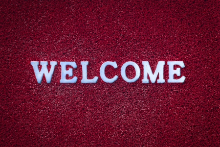 Light blue welcome text on red carpet texture