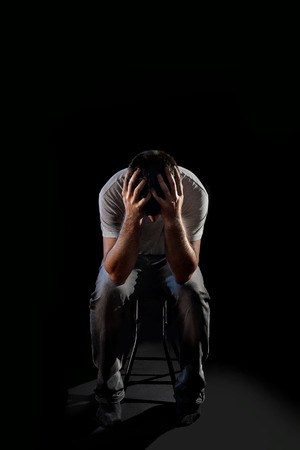 絶望的な若者の苦しみと深い抑うつ状態 痛みと感情的な障害 悲しみと絶望の概念と黒の背景の分離でエッジの効いたとグランジ スタジオ照明に手で顔を覆っています の写真素材 画像素材 Image
