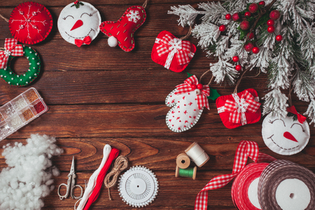 Felt christmas decorations on the wooden table preparing for handmade