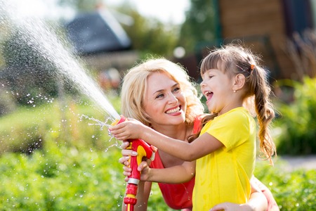 Happy mother and child daughter working in the garden
