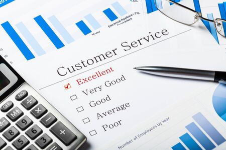 Pen, calculator and business graphs on questionnaire