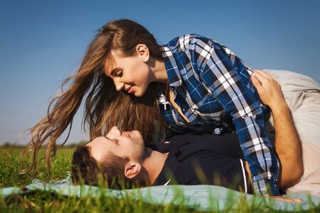teenagers lie on the grass. girl top of the guy Stock Photo - 70021520