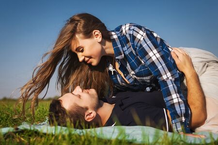 teenagers lie on the grass. girl  top of the guy Stock Photo - 70021520