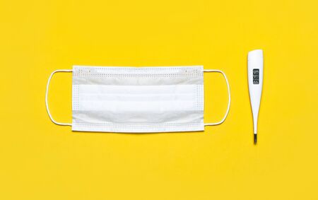 Medical Mask And Electronic Thermometer On Yellow Background Stock Photo Picture And Royalty Free Image Image 139924781