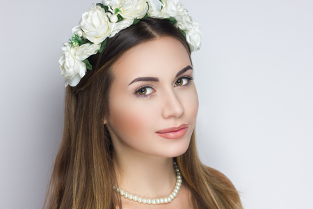 ファッショナブルなティアラの花の花とプロのメイクアップを持つ若い美しい女の子の女性 長いストレートヘア ジュエリー真珠のネックレス 矢印ベージュのアイシャドウ 自然なヌード唇 高級ジュエリー の写真素材 画像素材 Image