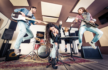 Woman beat guitar: Ban nhạc rock chơi hard rock trong studio. Khái niệm về giải trí và âm nhạc