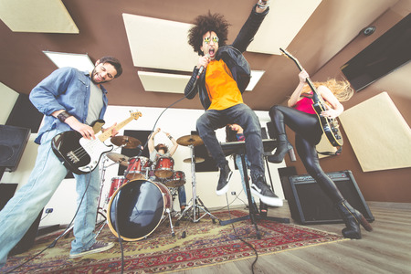 Woman beat guitar: Ban nhạc rock chơi hard rock trong studio. Khái niệm về giải trí và âm nhạc
