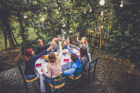 Group of friends at restaurant outdoors - People having dinner in a home garden - 67215633