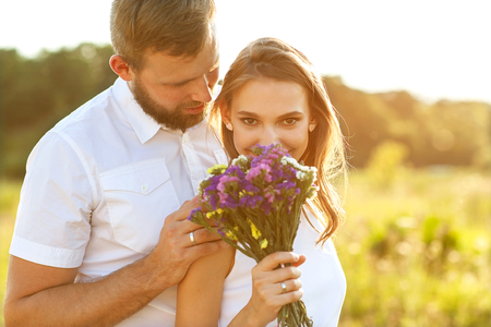 65300962-pareja-en-el-amor-a-la-naturaleza-el-hombre-besa-a-la-chica-en-la-mejilla-y-da-sus-flores.jpg?ver=6