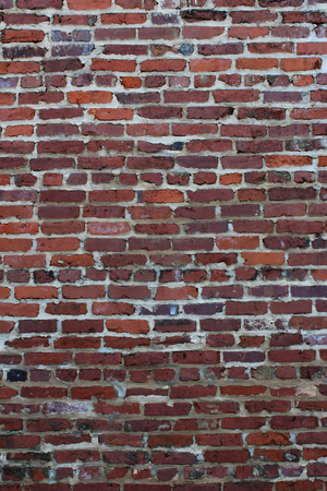wall of old brick in shades of red with repointing evident stock