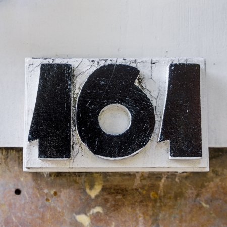 Wood sculptured house number one hundred and sixty one black lettering on a white background Фото со стока Wood sculptured house number one hundred and sixty one black lettering on a white background Фото со стока