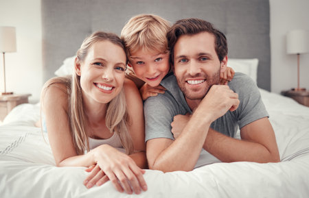 Mother, father or boy bonding in bedroom at home, house or hotel in trust, love or safety. family portrait, smile or happy man or woman and child, kid or son on relax security bed in canada apartment Mother, father or boy bonding in bedroom at home, house or hotel in trust, love or safety. family portrait, smile or happy man or woman and child, kid or son on relax security bed in canada apartment