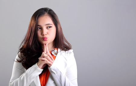 彼女の側に空の空間を見ながらかわいい顔を作る白いスーツで魅力的なアジアの女の子 の写真素材 画像素材 Image