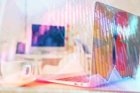 Stock market graph on background with desk and personal computer multi exposure concept of financial analysis