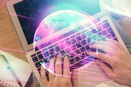 Double exposure of man s hands typing over computer keyboard and tech theme hologram drawing top view technology concept