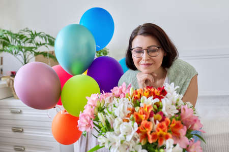 Portrait Of Middle Aged Happy Woman With Bouquet Of Flowers, Balloons