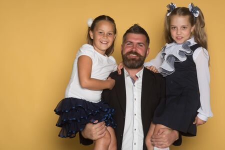 笑顔が女子中学生 幸せそうな顔のひげを生やした男は 小学生を保持しています 教育と学校のコンセプトです 背景が黄色の制服の女の子 の写真素材 画像素材 Image