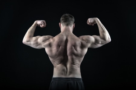 ダイエットとフィットネス 健康 スポーツとワークアウト 裸の胸を持つコーチスポーツマン 黒い背景に隔離されたズボンで運動ボディビルダーポーズ 筋肉質の体 背中 二頭筋を持つ男 の写真素材 画像素材 Image