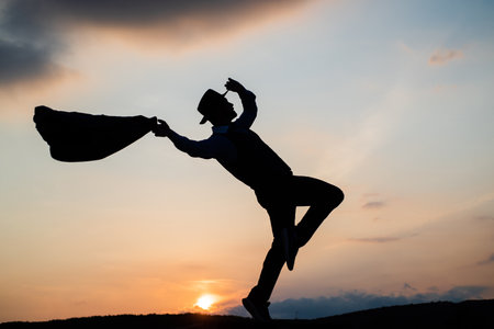 La silhouette de l'homme saute et danse sur fond de ciel. homme d'affaires confiant en cours d'exécution. motivation quotidienne