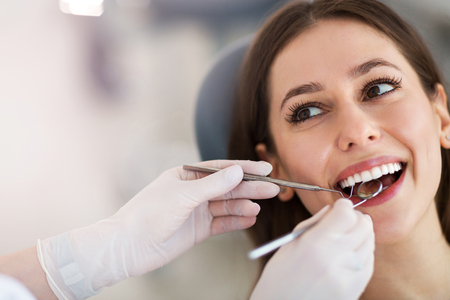 Mujer que tiene dientes examinados en dentistas Foto de archivo - 98213452