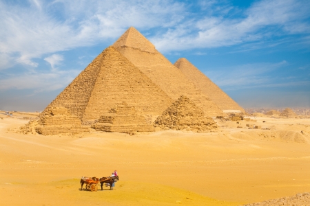 The giza pyramids lined up in a row against a beautiful blue sky in cairo egypt 免版税图像