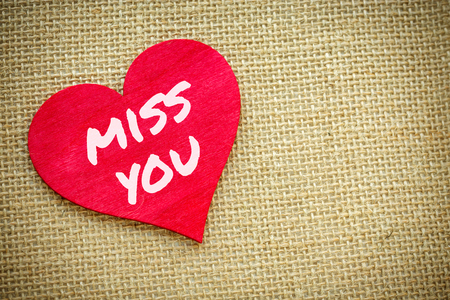 Closeup on Heart with Miss you word isolated on a burlap fabric. Valentines Day and love concept - 92150009